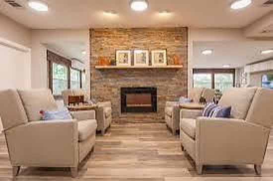 Living room with a stone fireplace and upholstered armchairs